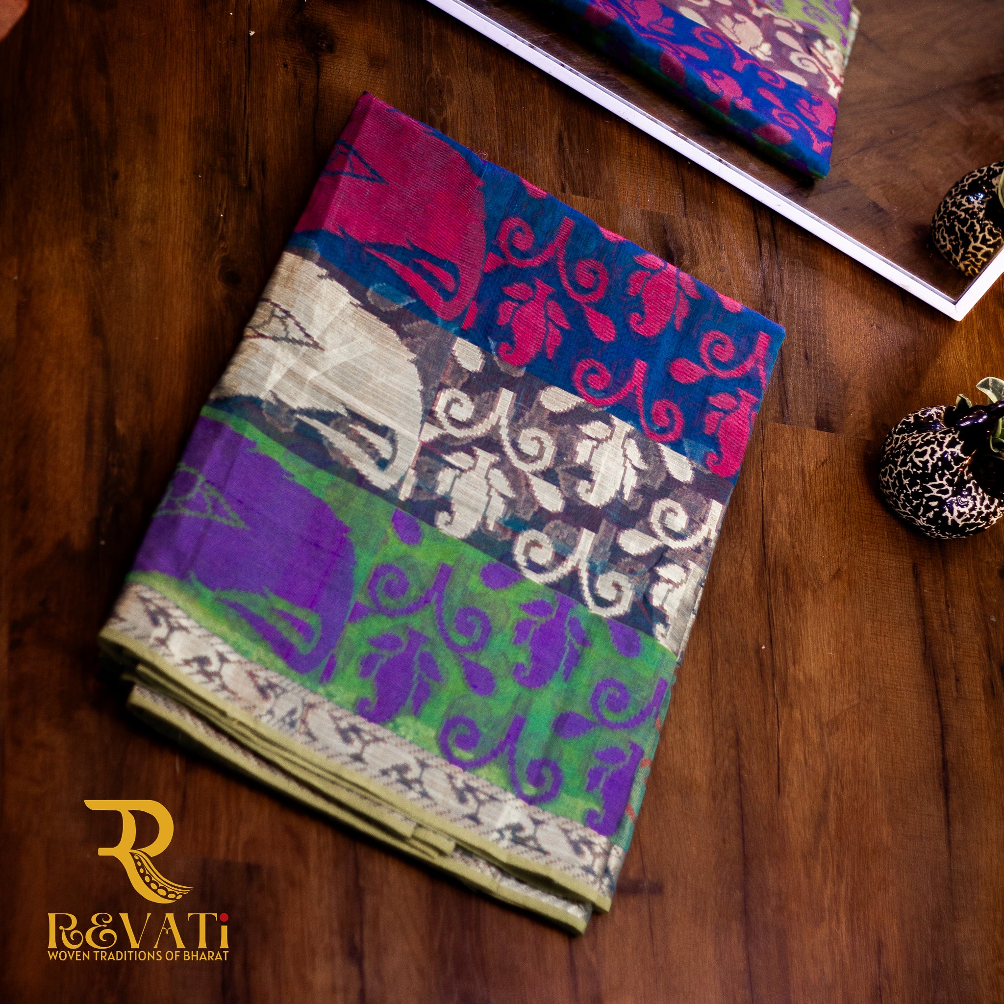 Multi-toned cotton-silk saree featuring Ikat-inspired woven bands, subtle metallic threadwork, and softly shimmering zari borders.