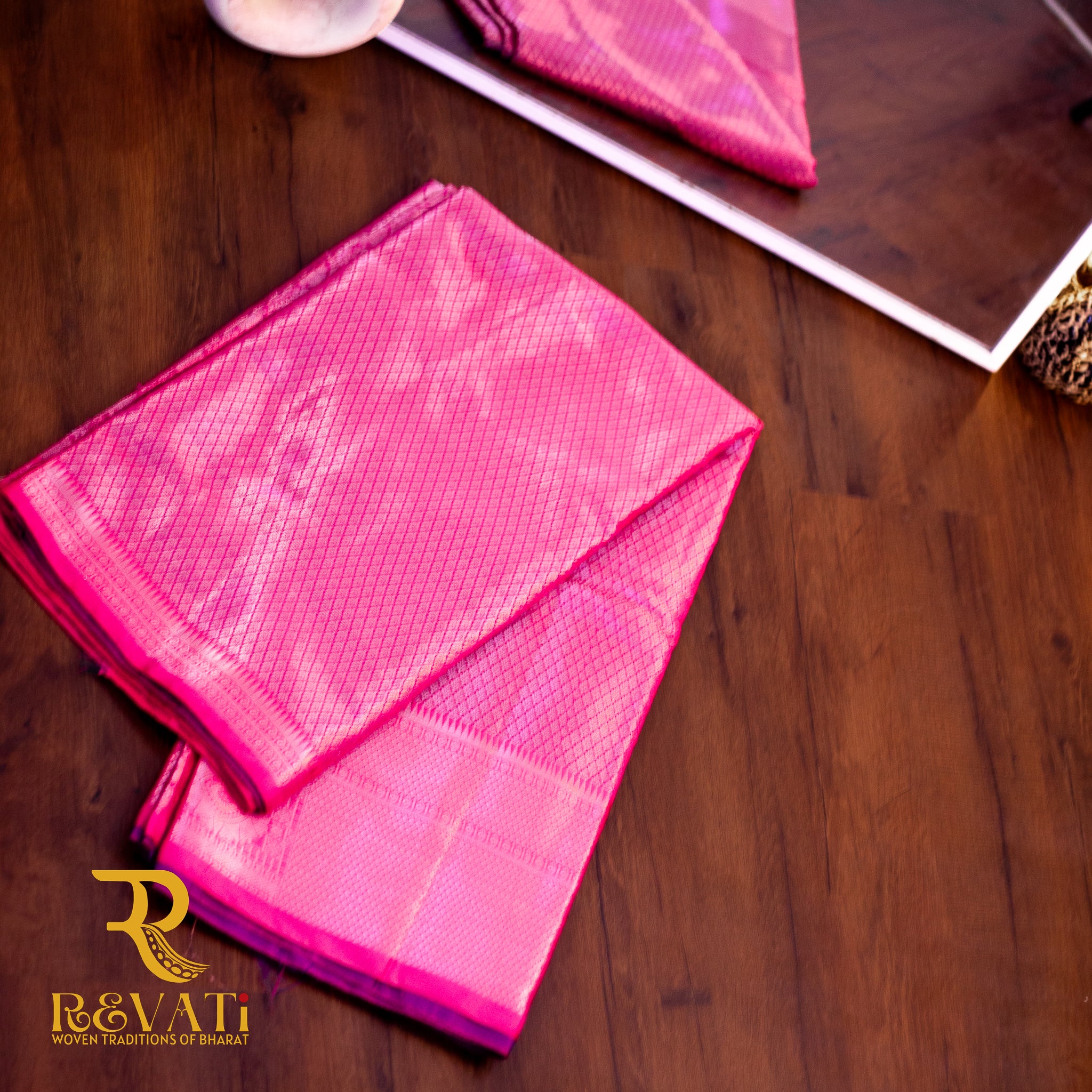 Pink handloom art silk saree with diamond weave, ornate zari borders, and a rich purple floral brocade pallu.