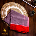 Charcoal grey handwoven cotton saree featuring a subtle linear self-weave, striking red zigzag borders, and effortless everyday elegance.