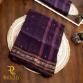Black handloom cotton saree with subtle stripes, delicate butis, and a gold zari floral border.