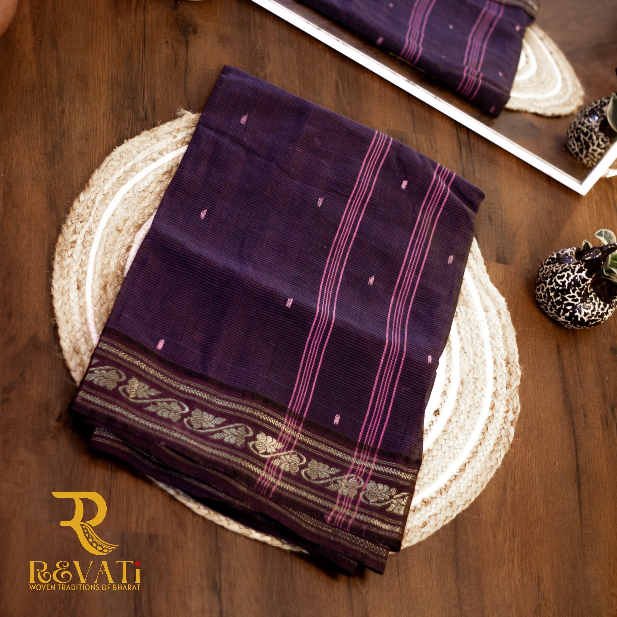 Black handloom cotton saree with subtle stripes, delicate butis, and a gold zari floral border.