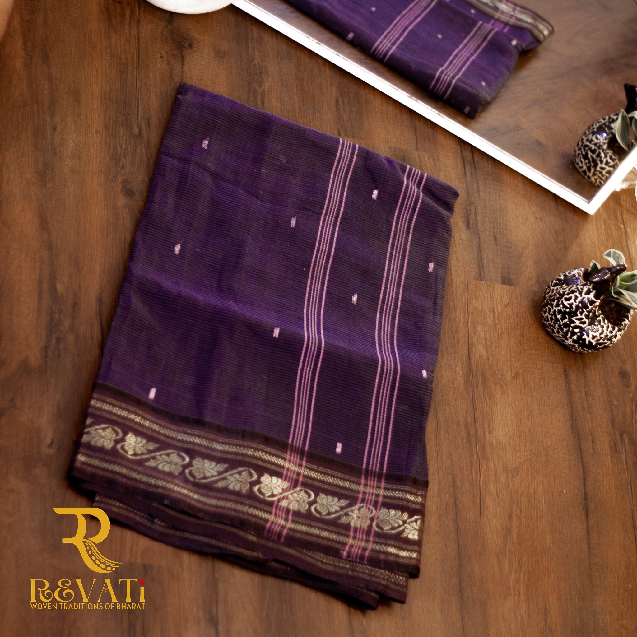 Black handloom cotton saree with subtle stripes, delicate butis, and a gold zari floral border.