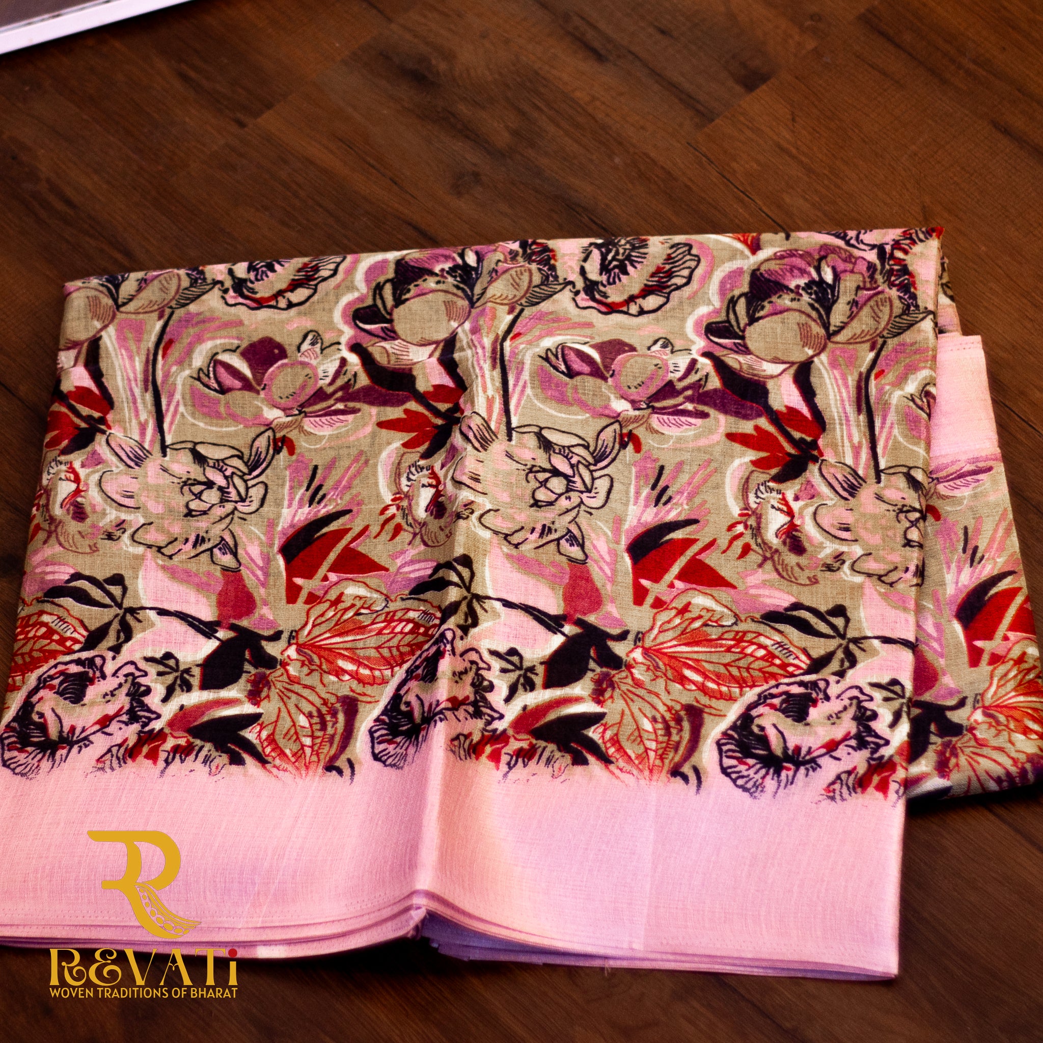 Beige linen-blend saree adorned with bold pastel florals in soft hues and finished with an elegant pink woven border.