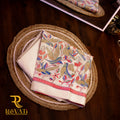 Bold crimson handloom cotton saree with multicolor Kalamkari edging and bird motifs.