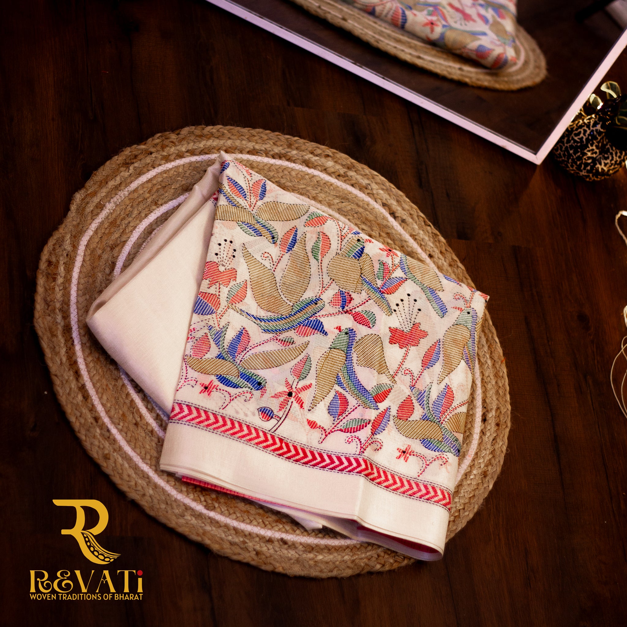 Bold crimson handloom cotton saree with multicolor Kalamkari edging and bird motifs.