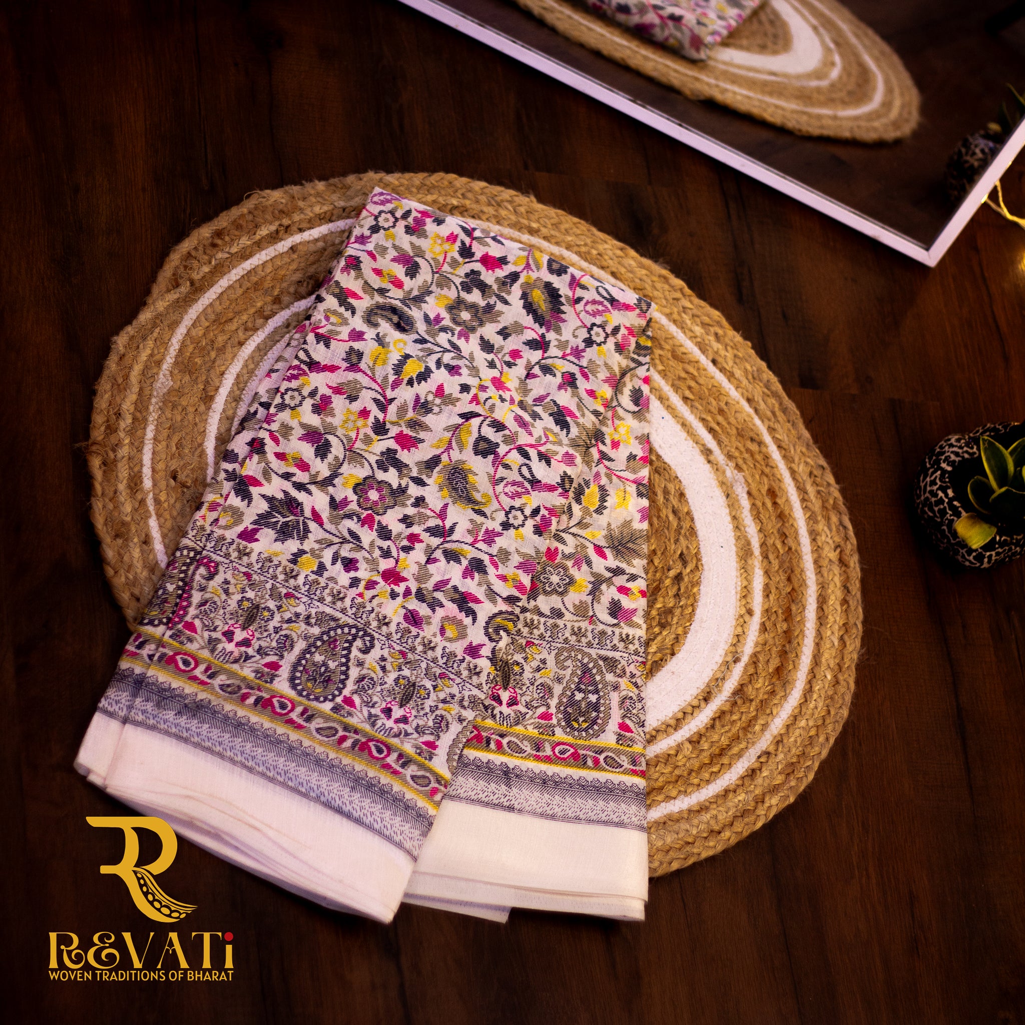 Creamy white linen-cotton saree with vibrant florals and soft thread-highlighted borders
