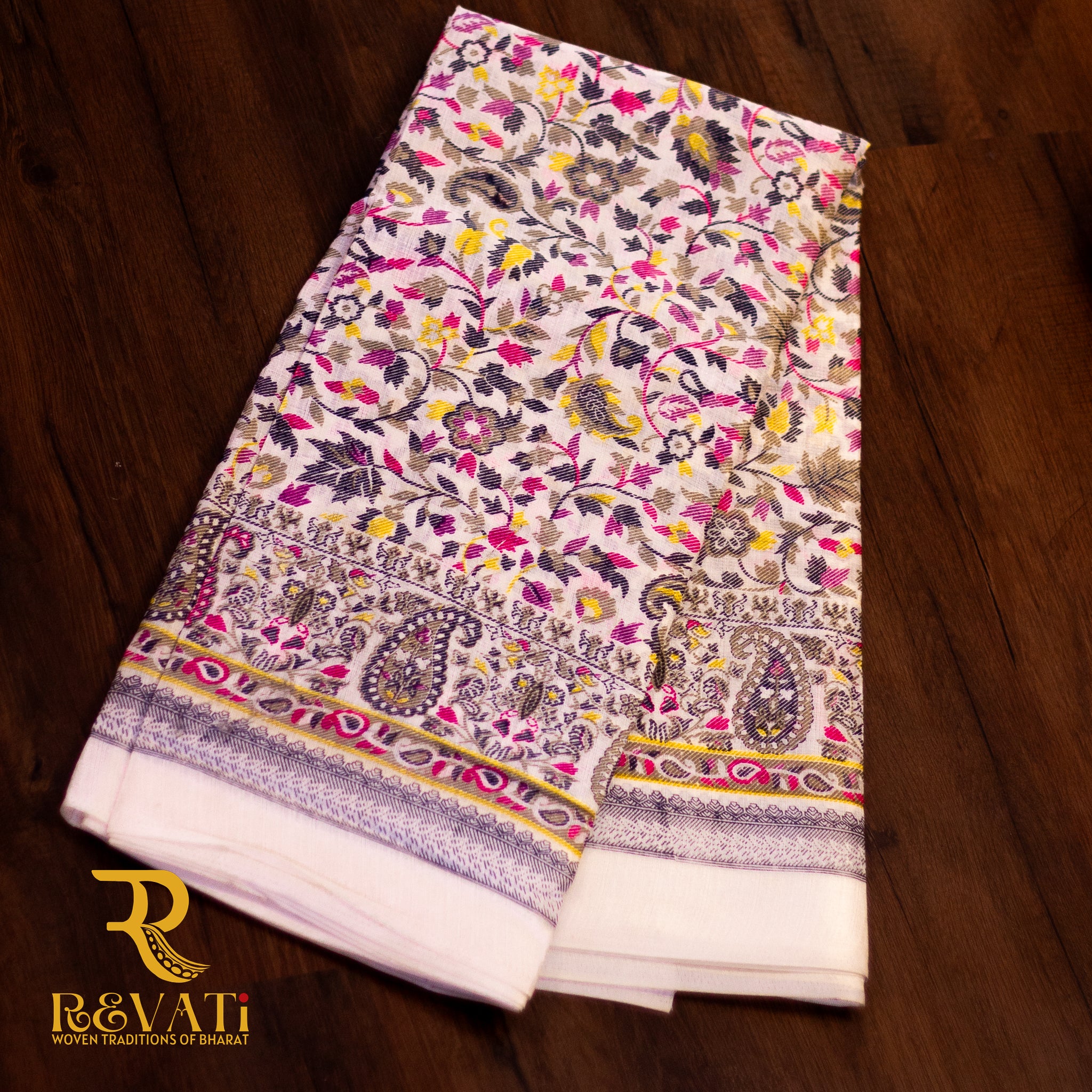 Creamy white linen-cotton saree with vibrant florals and soft thread-highlighted borders