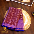 Royal blue and maroon jacquard silk saree featuring diamond-check motifs, vertical floral zari patterns, and broad silver-woven borders for a regal finish.